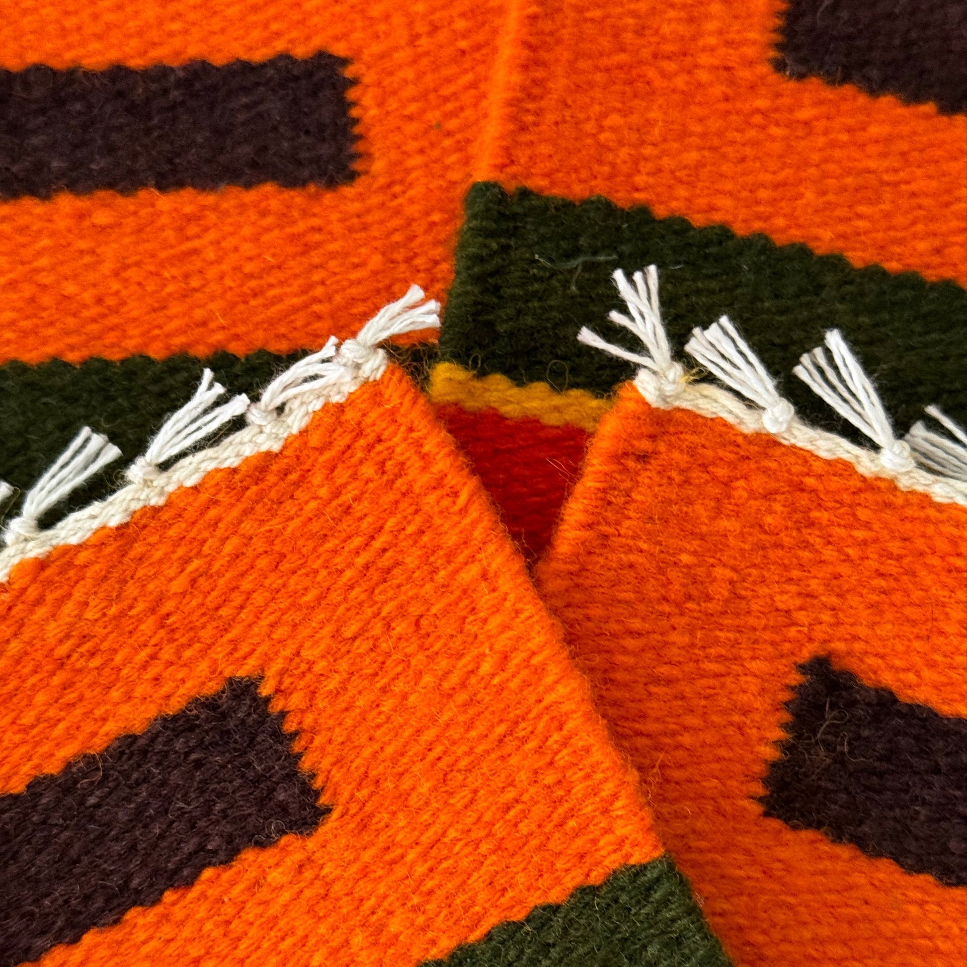 close up of handwoven sheep´s wool coasters with geometric patterns, crafted using natural Peruvian dyes.