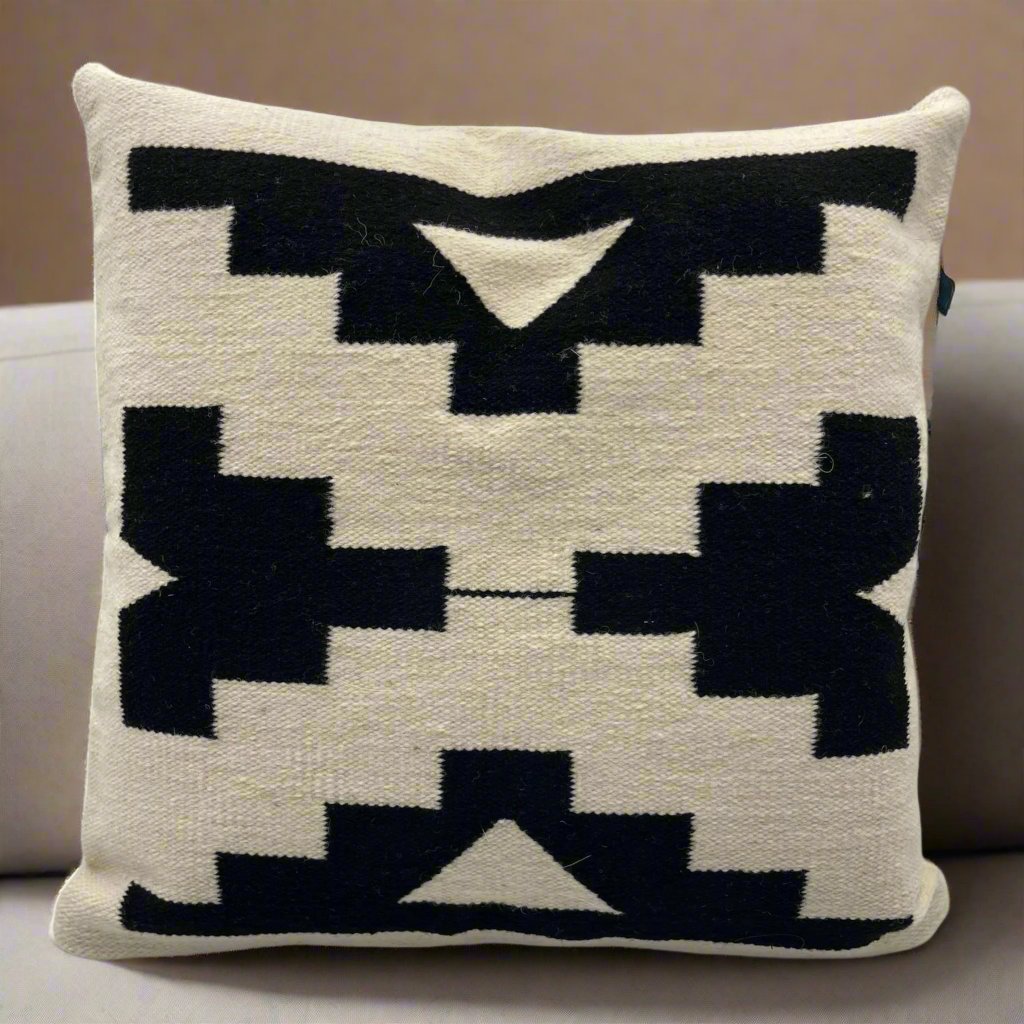 Black and natural color Luma Kuna cushion cover, showcasing intricate handwoven details made from Peruvian sheep’s wool and dyed with natural pigments